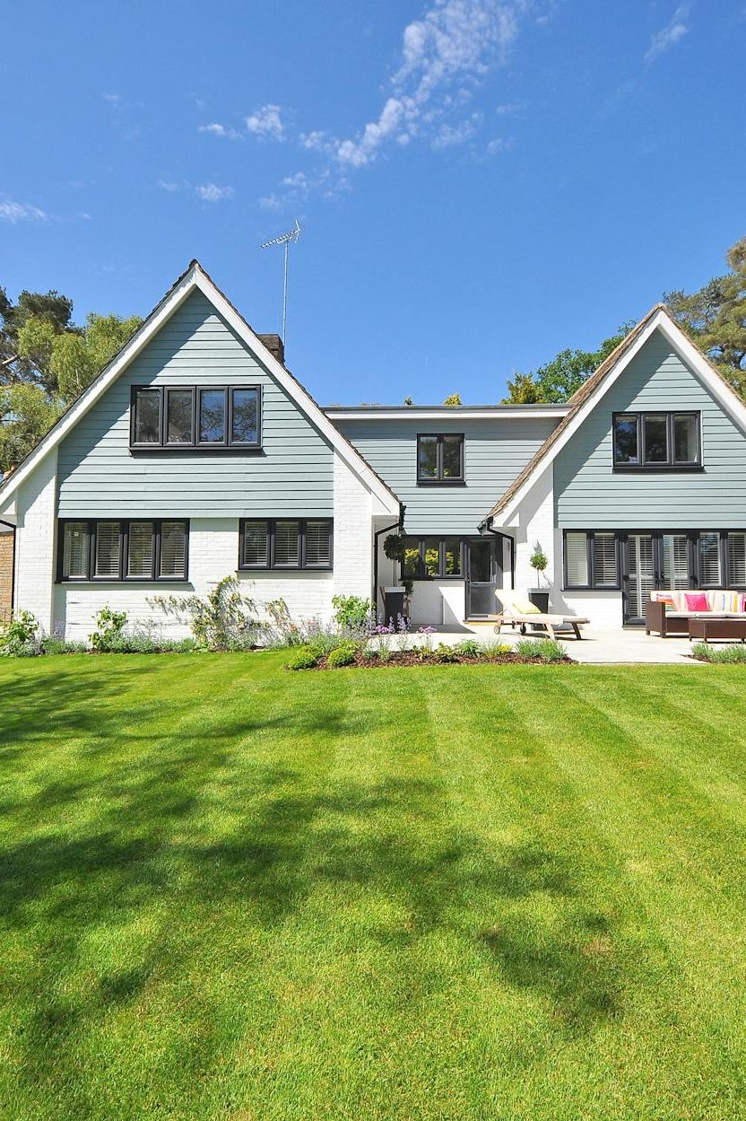 white and gray wooden house near grass field and trees